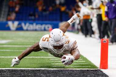 SAN ANTONIO, TEXAS - DECEMBER 29: Bijan Robinson #5 of the Texas Longhorns dives for a...