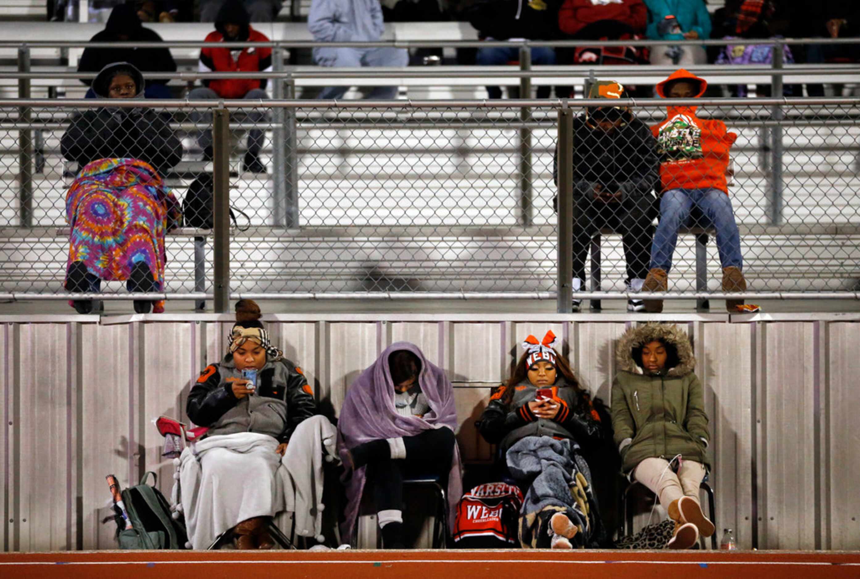 Lancaster High students try to keep warm during the game against The Colony during their...