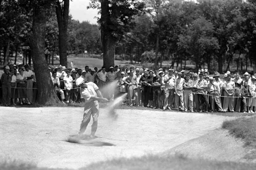 Ben Hogan, who came in with a one-under par 69, blasts from a sand trap on the edge of the...