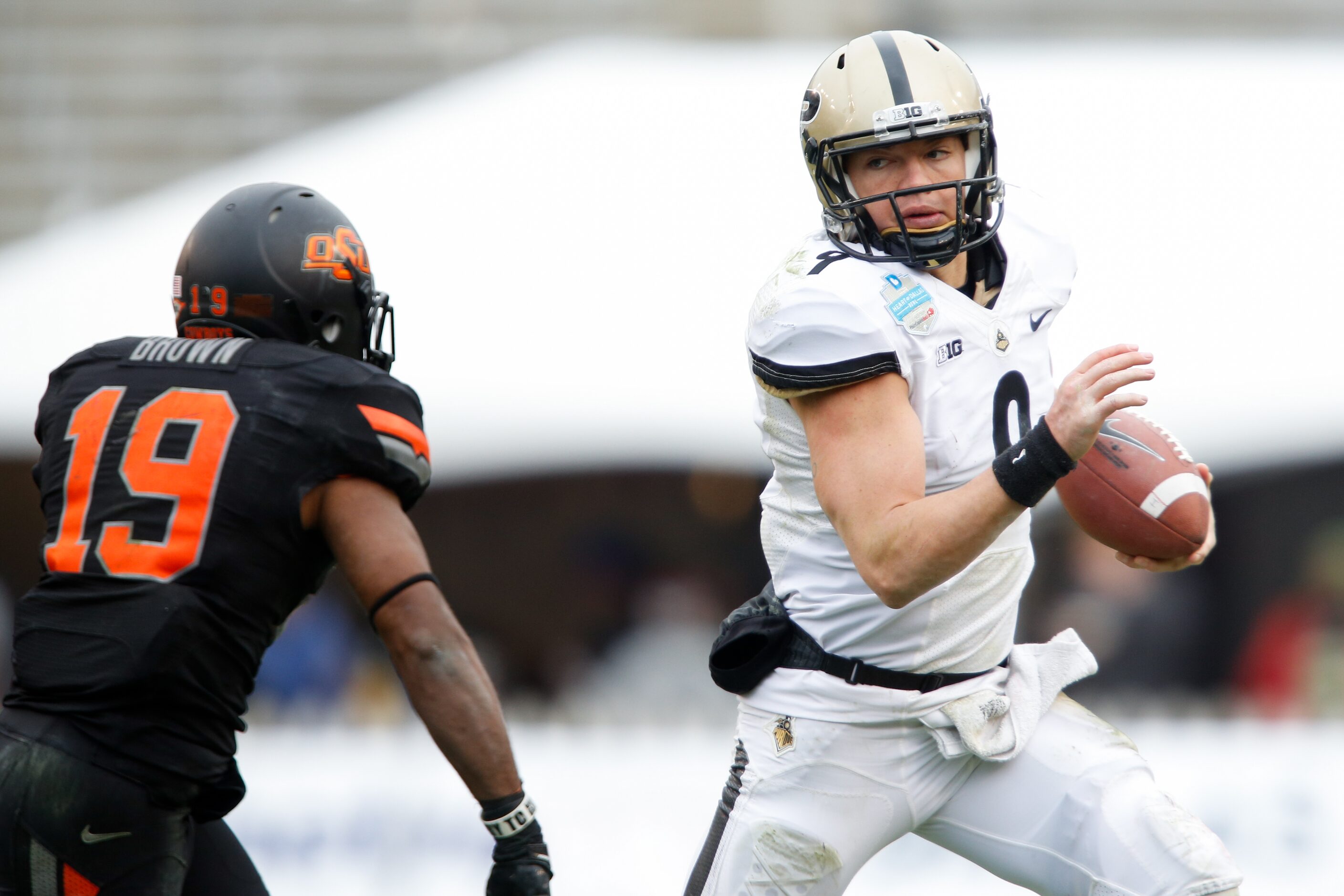 Purdue's quarterback Robert Marve (9) tries to outrun Oklahoma State's Brodrick Brown (19)...