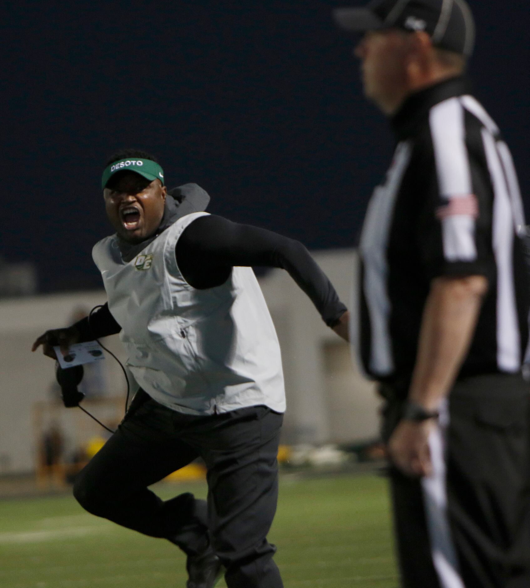 DeSoto head coach Claude Mathis attempts to get the attention of a game official to notice...