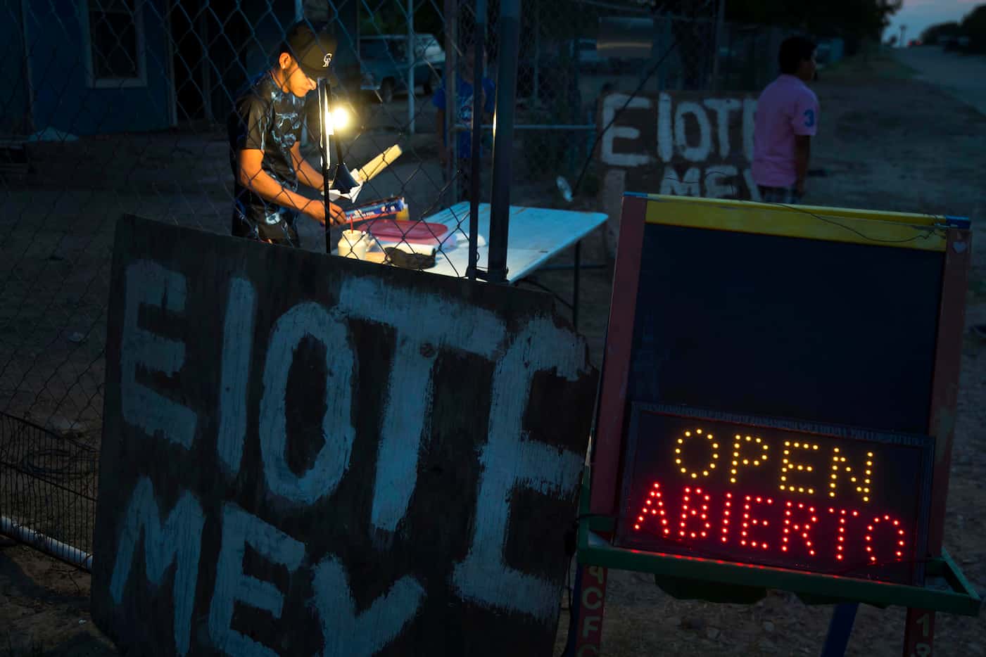 Cesar Rivera sells Elotes (grilled Mexican street corn) outside his grandmother's home in El...
