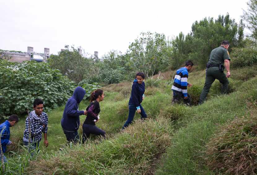 Migrants from Honduras and Guatemala are detained by the U.S. Border Patrol after crossing...