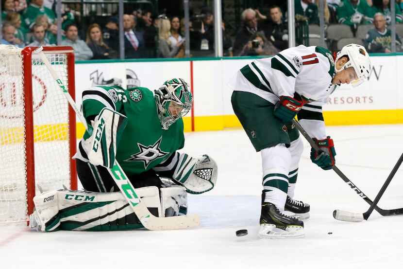 Minnesota Wild's Zach Parise (11) clears a path for a shot by a teammate as Dallas Stars'...