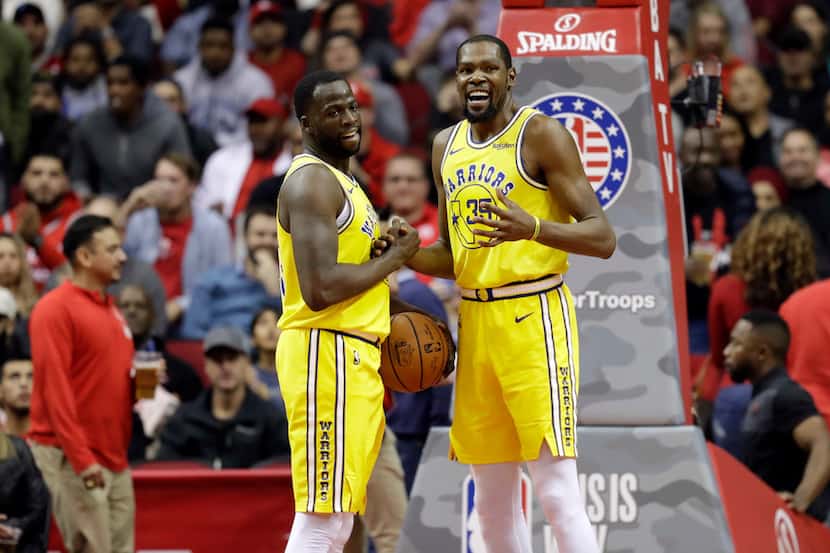 Golden State Warriors' Kevin Durant (35) talks with Draymond Green after a turnover during...