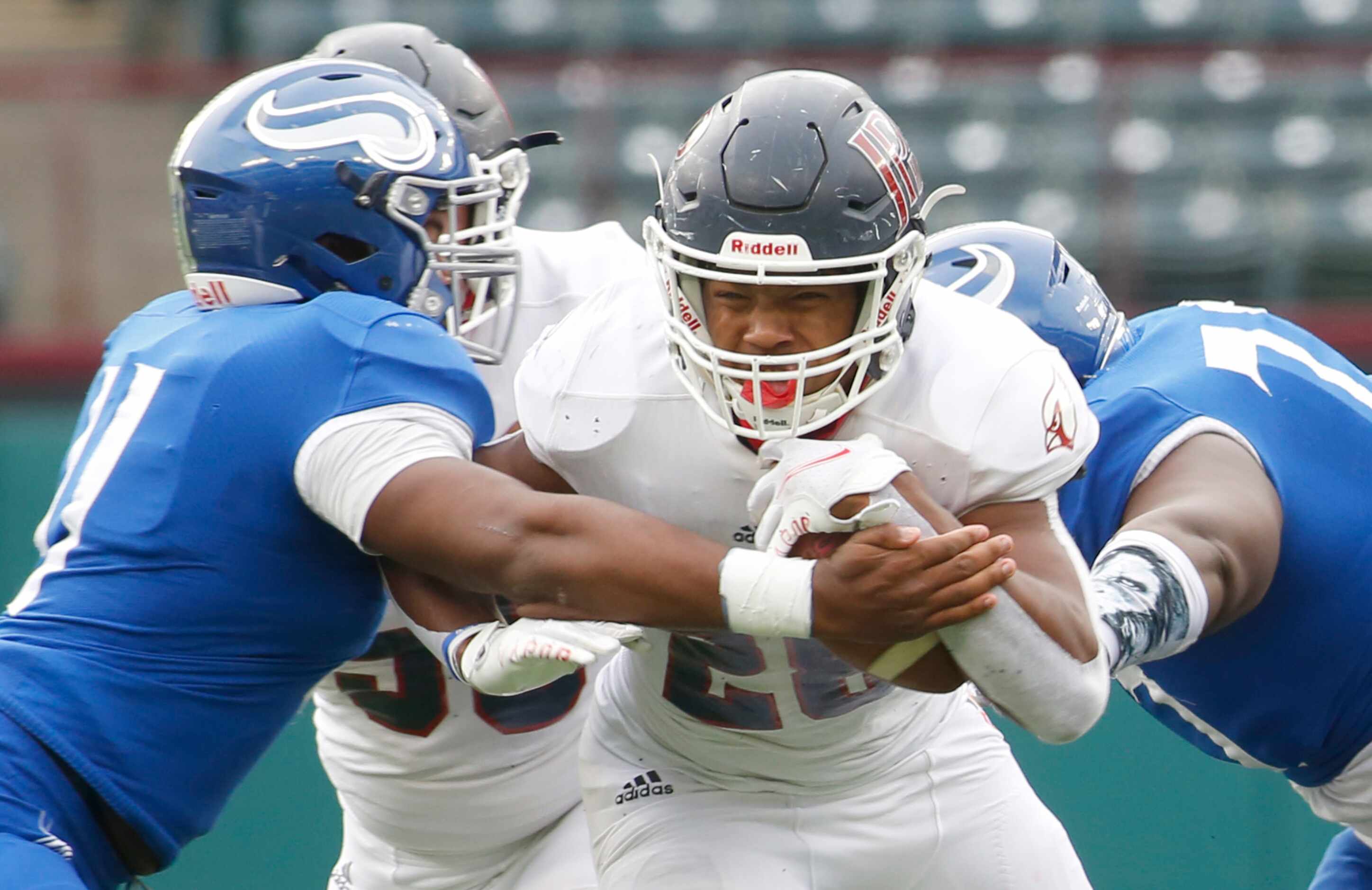 Plano John Paul ll running back Grant Robinson (28) winces as he tries to squeeze between...