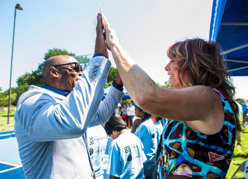 Former Dallas police chief David Brown high-fives women's basketball legend Nancy Lieberman...