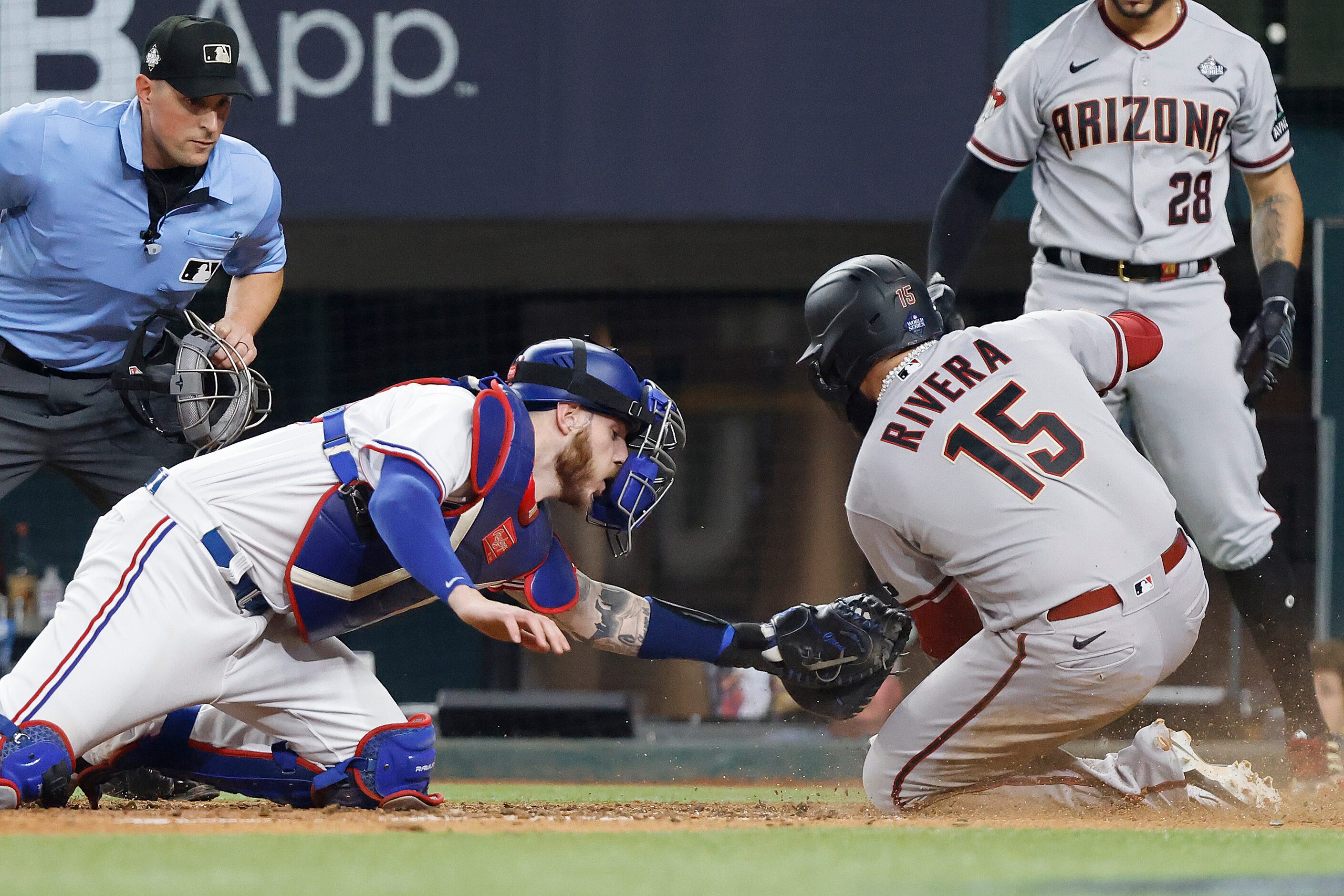 Texas Rangers catcher Jonah Heim misses the tag on Arizona Diamondbacks' Emmanuel Rivera as...