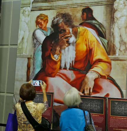 Visitors look at the photo reproduction of the Sistine Chapel at Fair Park. (Nathan...