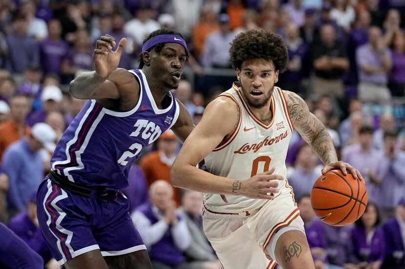 Texas forward Timmy Allen (0) works to the basket against TCU's Emanuel Miller (2) in the...