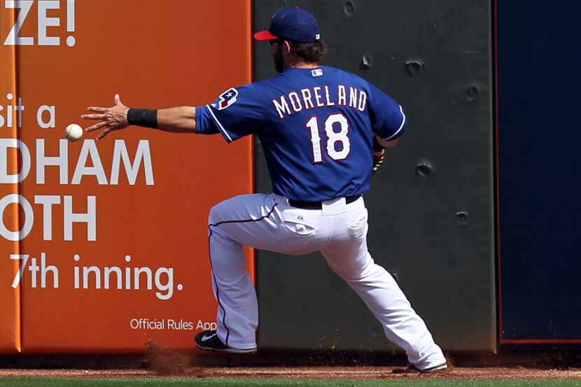 Mar 5, 2014; Surprise, AZ, USA; Texas Rangers outfielder Mitch Moreland (18) reaches for a...