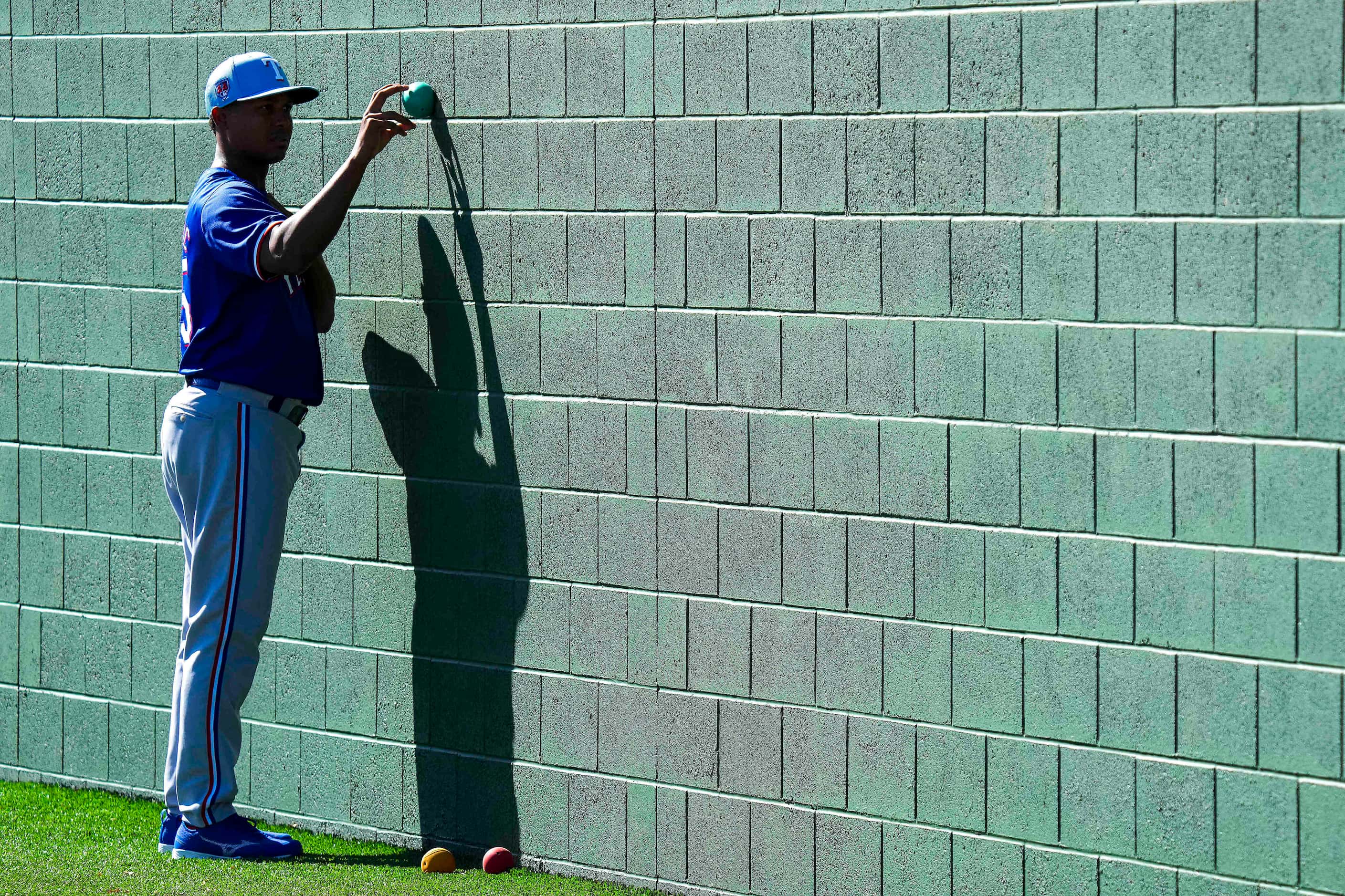 Texas Rangers pitcher José Leclerc tosses a ball against a wall during the first Spring...