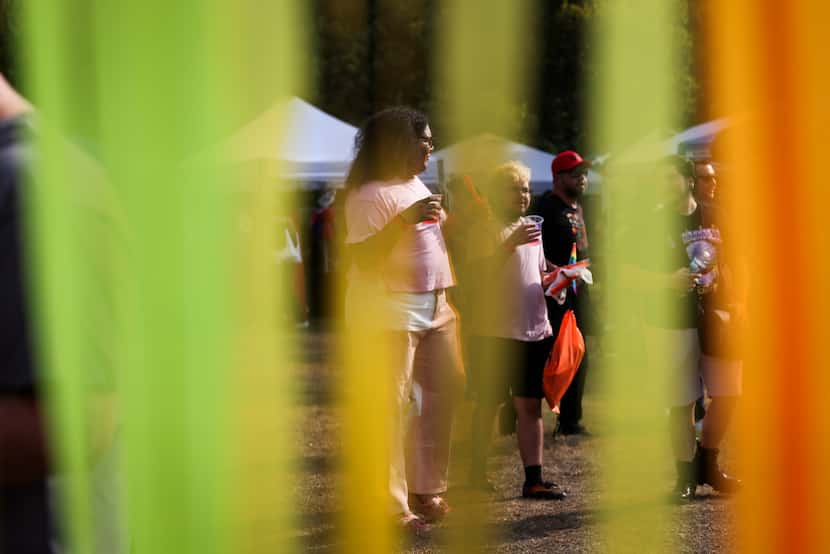 Festivalgoers walk past booths decorated with Pride rainbow colors during the festival. 
