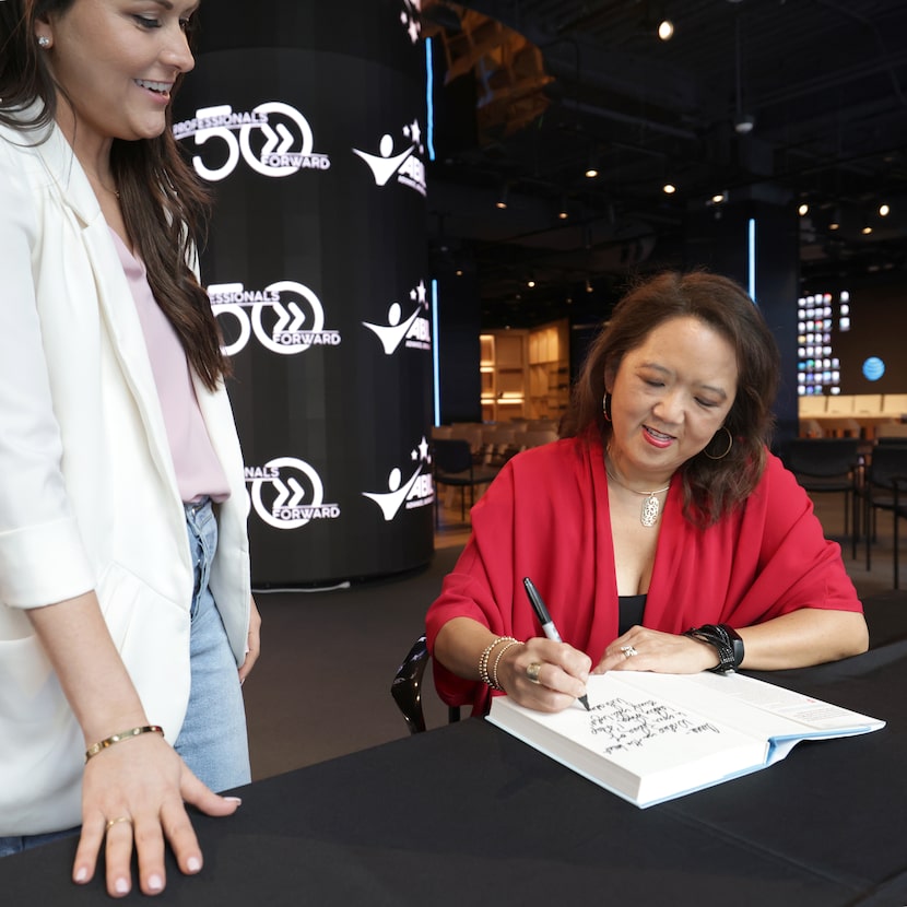 Anna Tipton, left, gets a book signed by Anne Chow, former CEO of AT&T Business, at the AT&T...