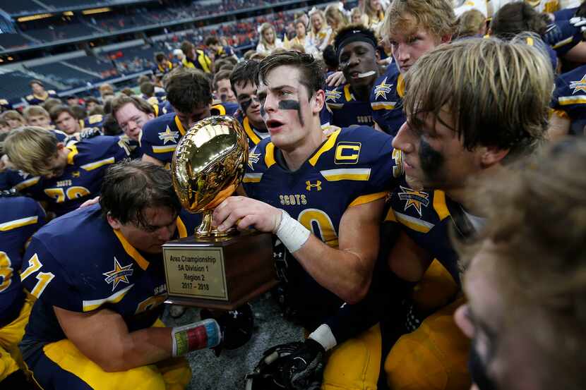 Highland Park's James Herring (30) holds the trophy as players gather for a group photo...
