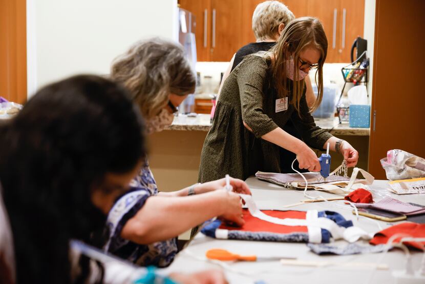 Victoria Scarborough (right) uses hot glue as she makes a tote bag at the Cancer Support...