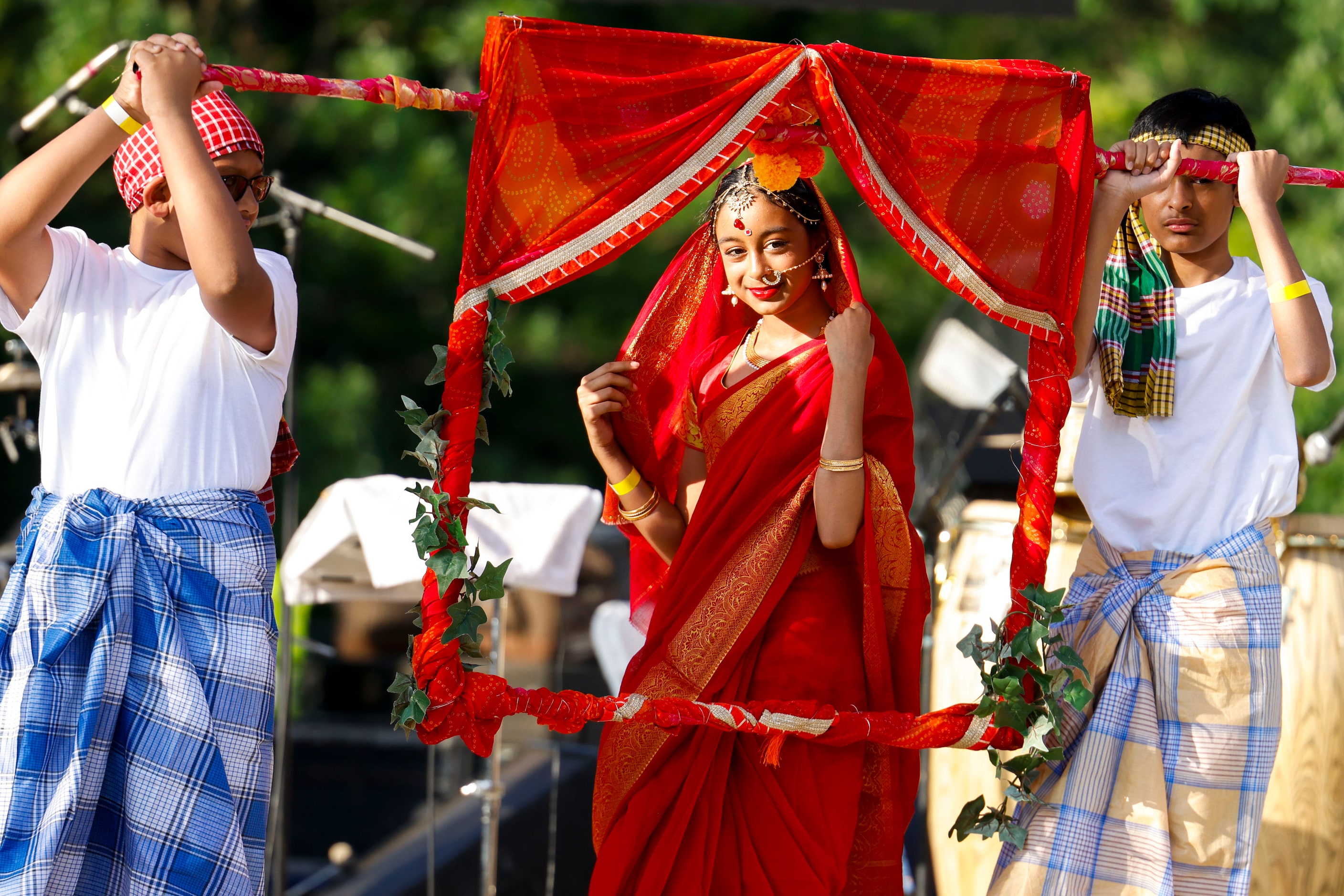 Raisa Siddique, 11, (center) remains behind a cutout of a 'palki,’ or Palanquin, carried by...