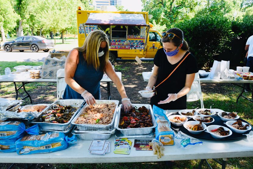 Volunteers Denise Jones (left) and Shoshana McIntosh plate food from One Love Caribbean...