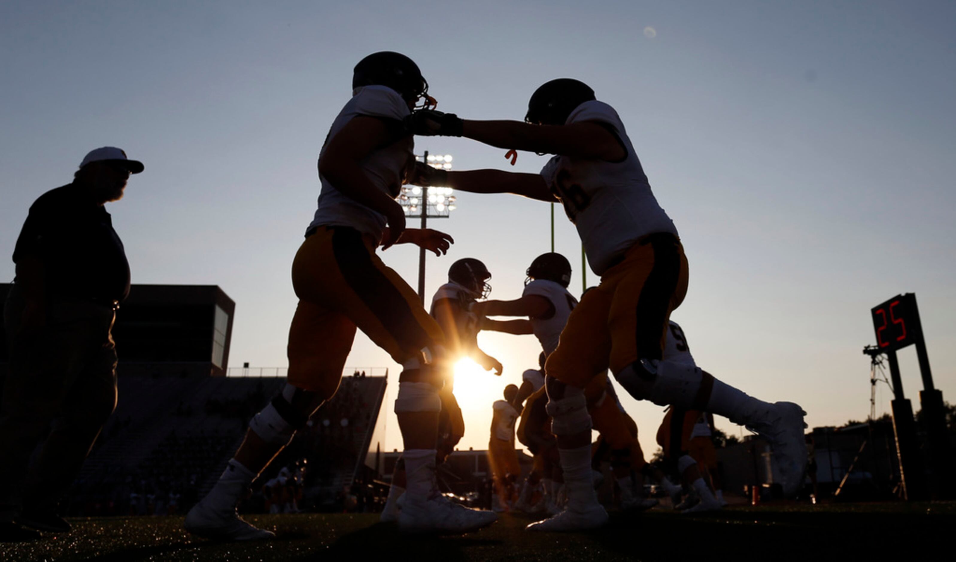 Highland Park players warmup with drills before the start of their high school football game...