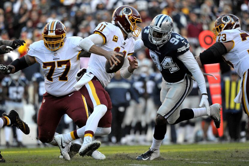 Washington Redskins quarterback Alex Smith (left) scrambles away from Dallas Cowboys...