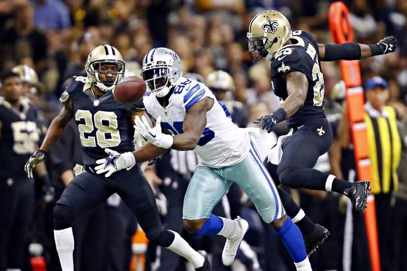 Dallas Cowboys wide receiver Dez Bryant (88) bobbles a pass under pressure from New Orleans...