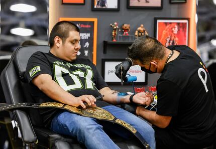 Jose Perez, 26, of Dallas gets a paint brush tattoo during a fan exhibition ahead of...