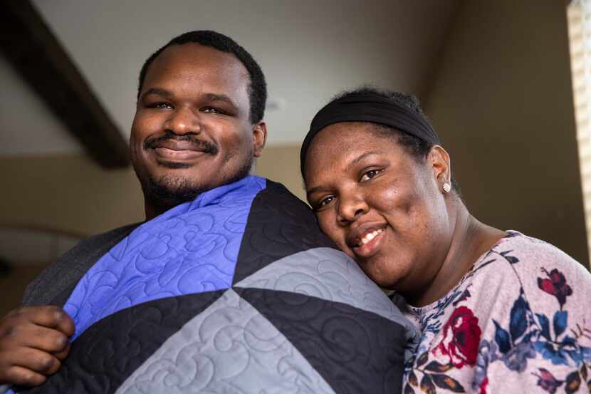 Draped in the survivor's quilt made by his mother-in-law, Kerry Parks poses for a portrait...