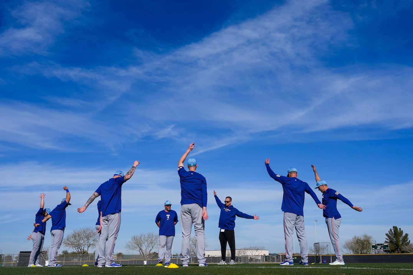 Texas Rangers catchers stretch during a spring training workout at the team's training...