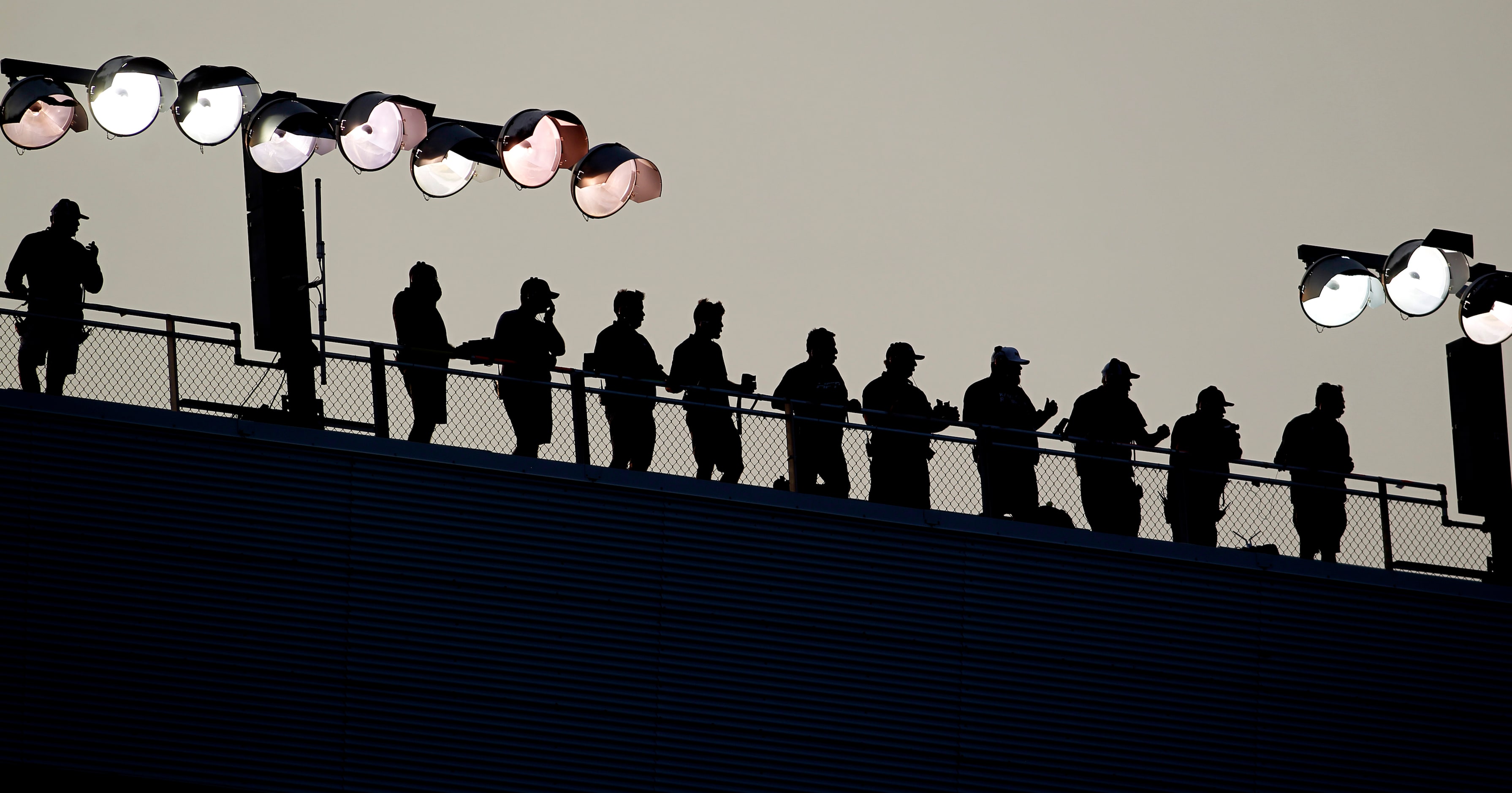 Race enthusiasts take advantage of a birds-eye-view from the top of stands during the start...