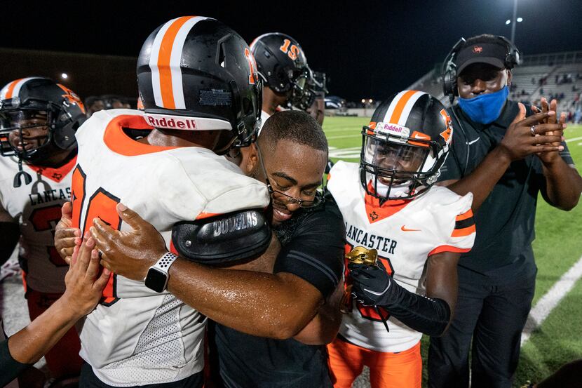 Lancaster head coach Leon Paul is congratulated by running back Isaiah Broadway (20) and...