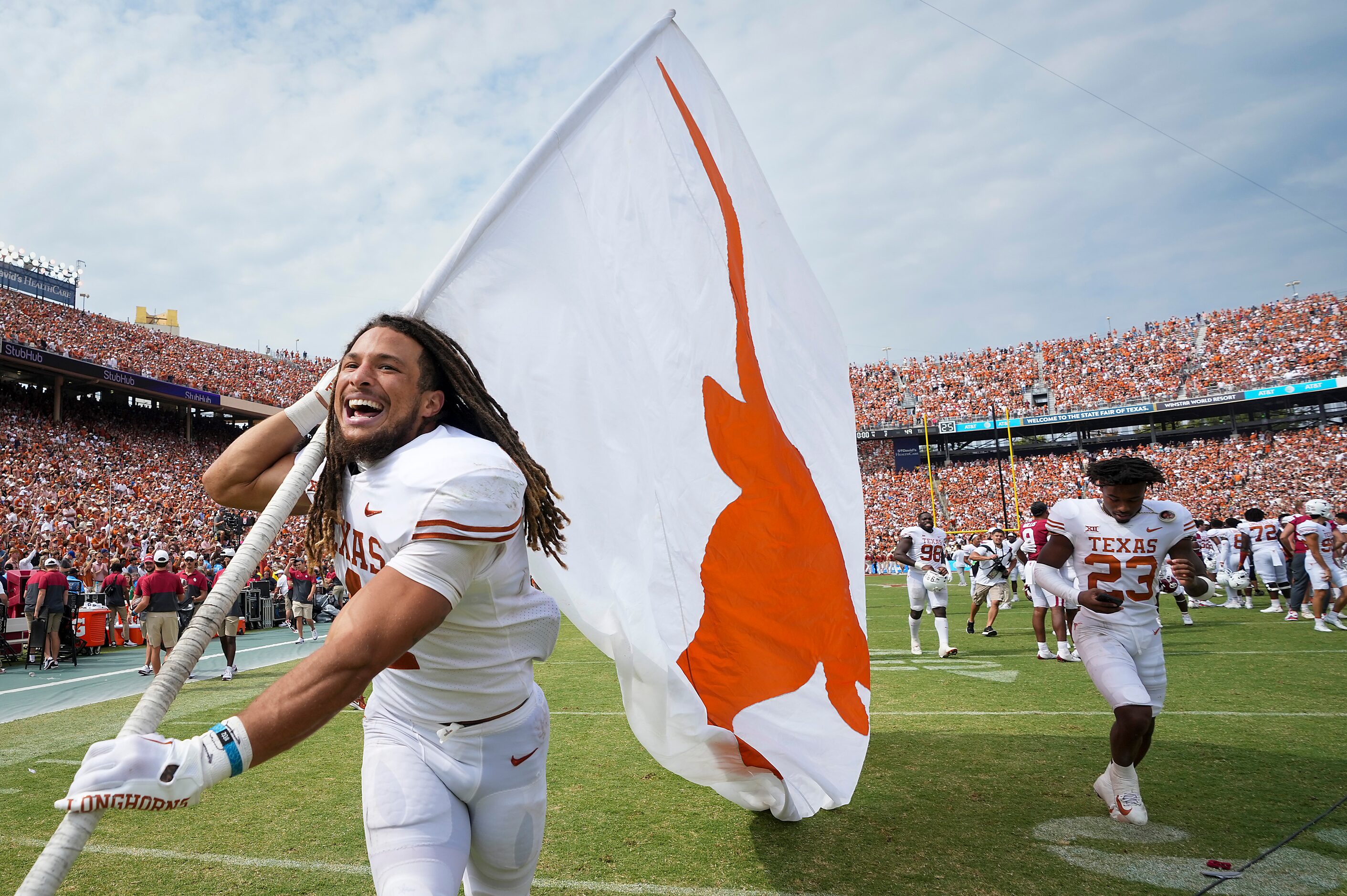 Texas wide receiver Jordan Whittington carries the Longhorns flag across the field in...