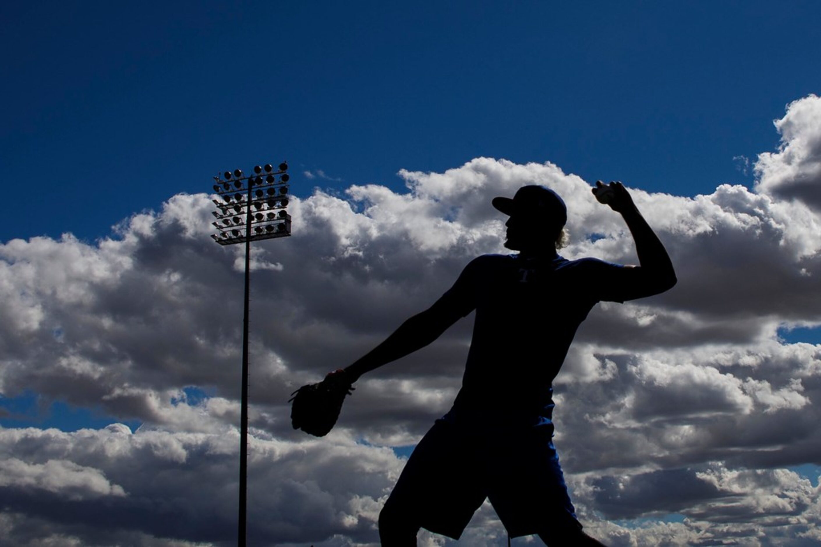 Texas Rangers infielder Ronald Guzman throws in the outfield during a spring training...