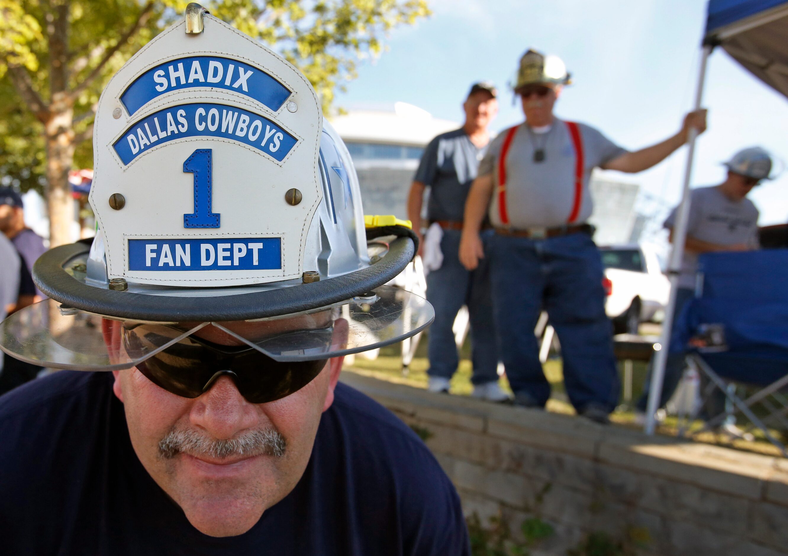 Ron Shadix poses with his fireman-themed hat as he tailgates with friends before the...