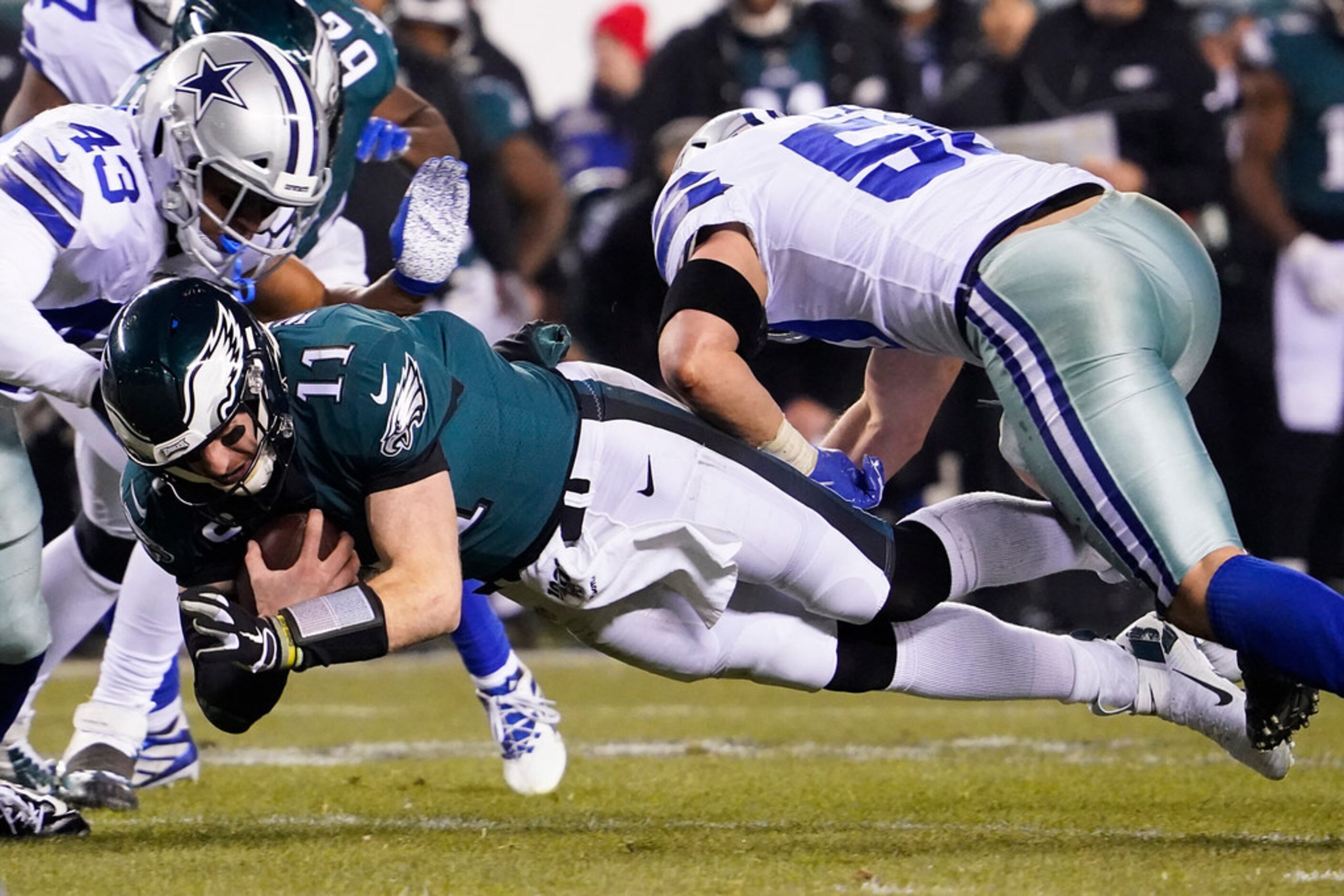 Philadelphia Eagles quarterback Carson Wentz (11) dives for yardage between Dallas Cowboys...