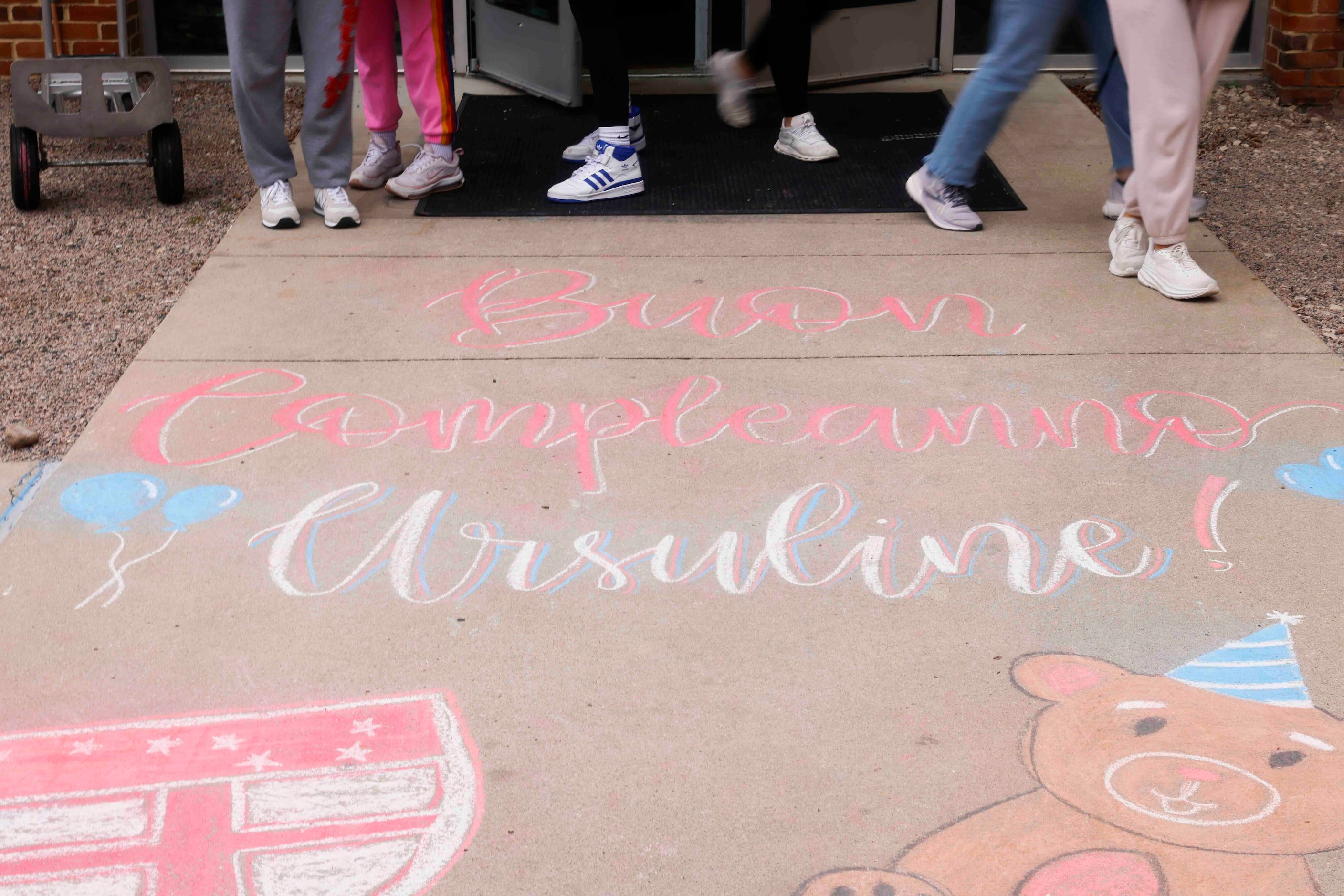 Students pass by celebratory messages written on the outside lawn during the 150th...