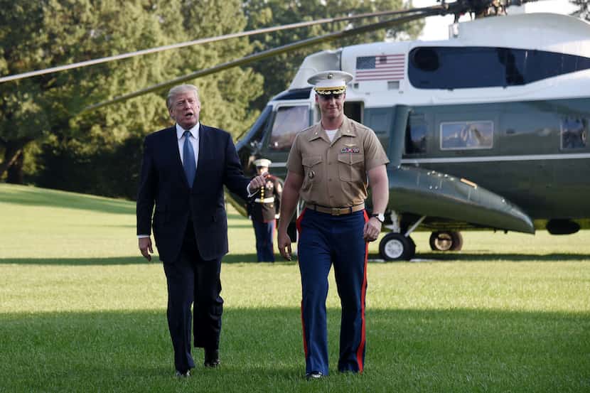 President Donald Trump walks toward the White House with pilot James Thompson Jr., who...