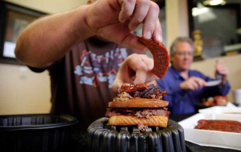 
The Texas BBQ Posse dismantles “The Jambo Texan” sandwich, piled high with brisket, chopped...