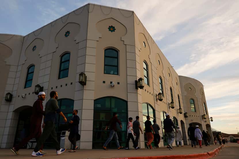 Muslims walk towards the main hall of Islamic Center of Irving ahead of a community Iftar in...