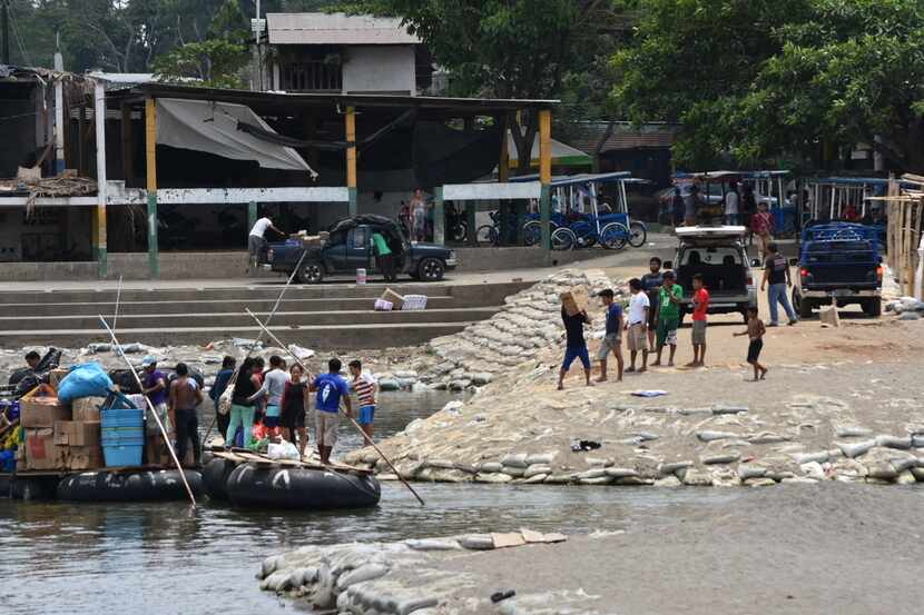 Varias personas intentan cruzar de Guatemala a México en una balsa hechiza por el Río...