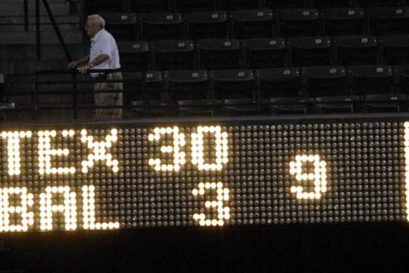 FILE - A scoreboard displays the final score in the first game of a baseball doubleheader...