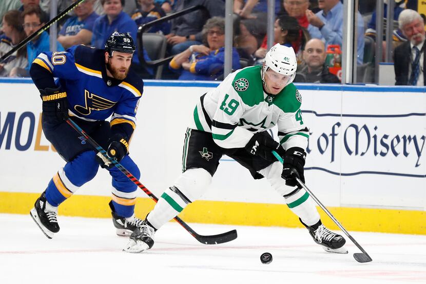 Dallas Stars' Rhett Gardner (49) and St. Louis Blues' Ryan O'Reilly chase after a loose puck...