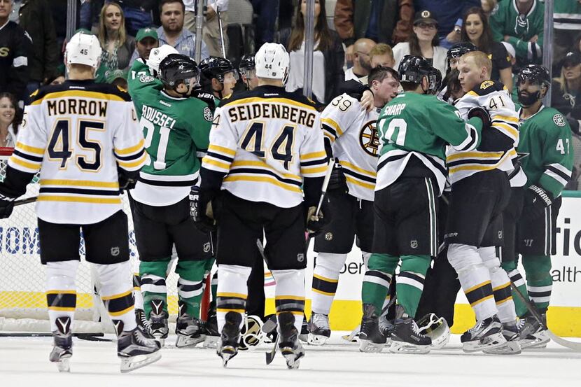 Dallas Stars and Boston Bruins fight following a shot on goal by the Bruins during the...