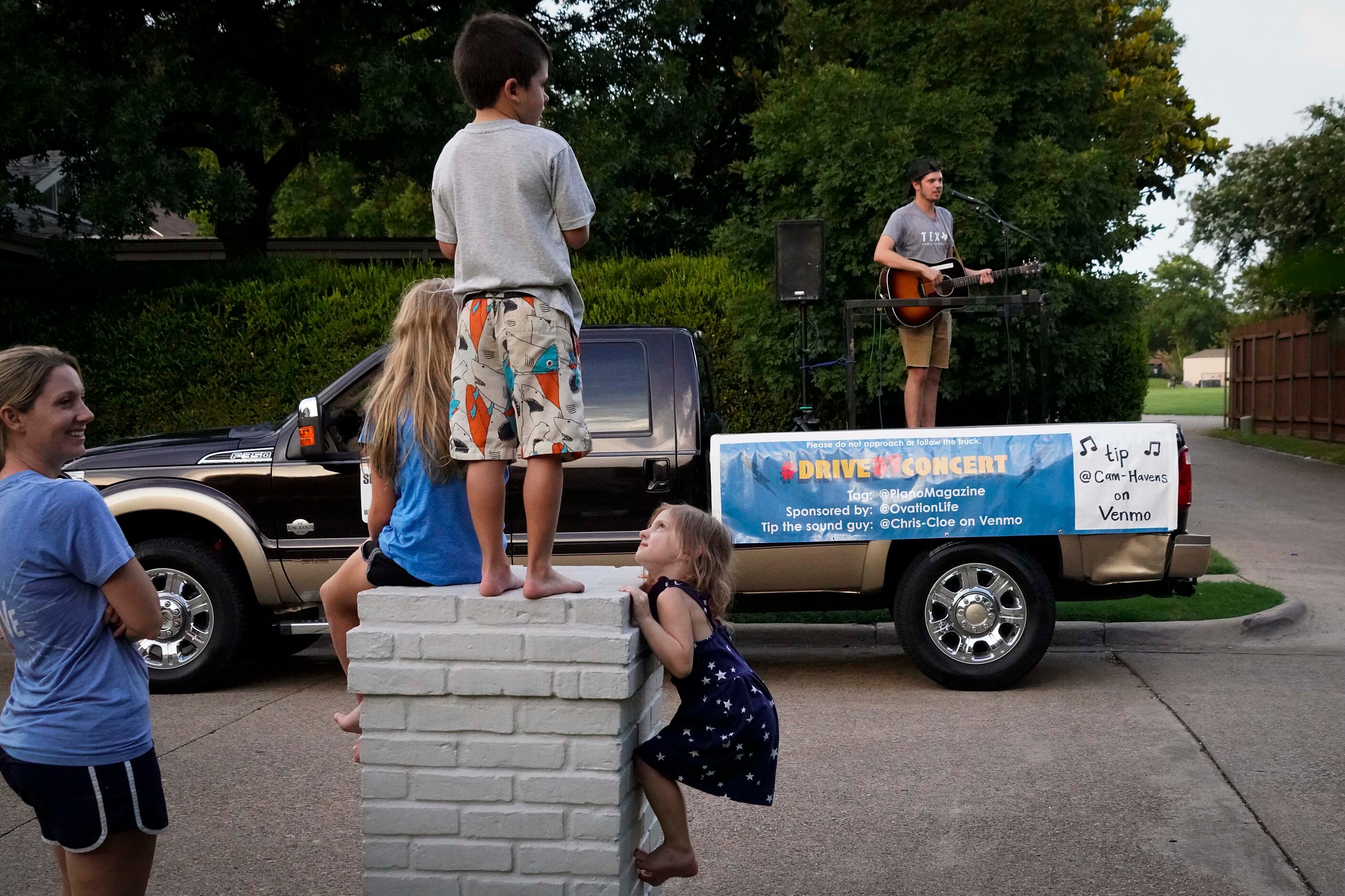 Cameron Havens sings from the back of a pickup truck during a 'Drive By Concert' through the...