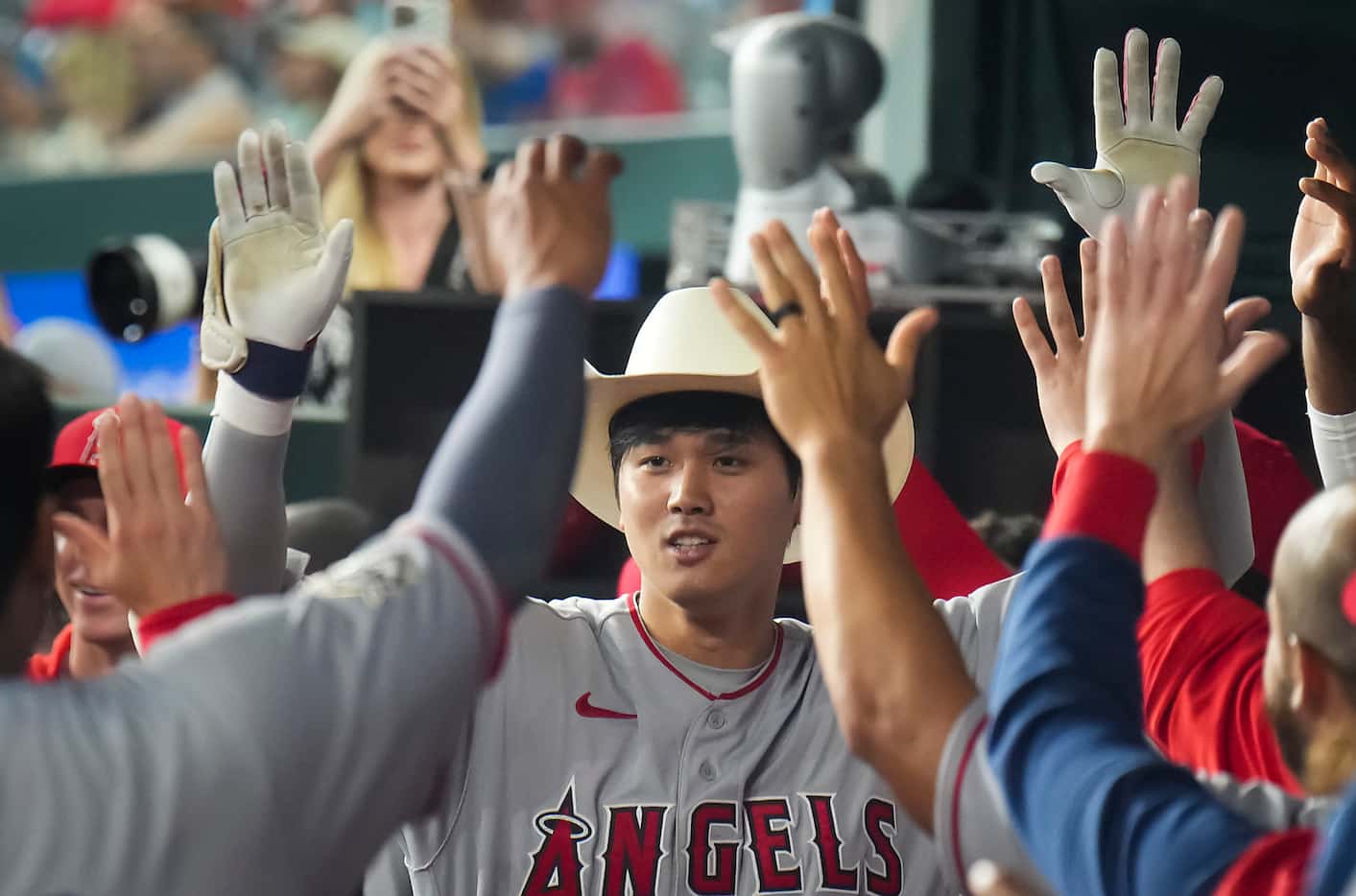 Los Angeles Angels designated hitter Shohei Ohtani celebrates in the dugout after hitting a...
