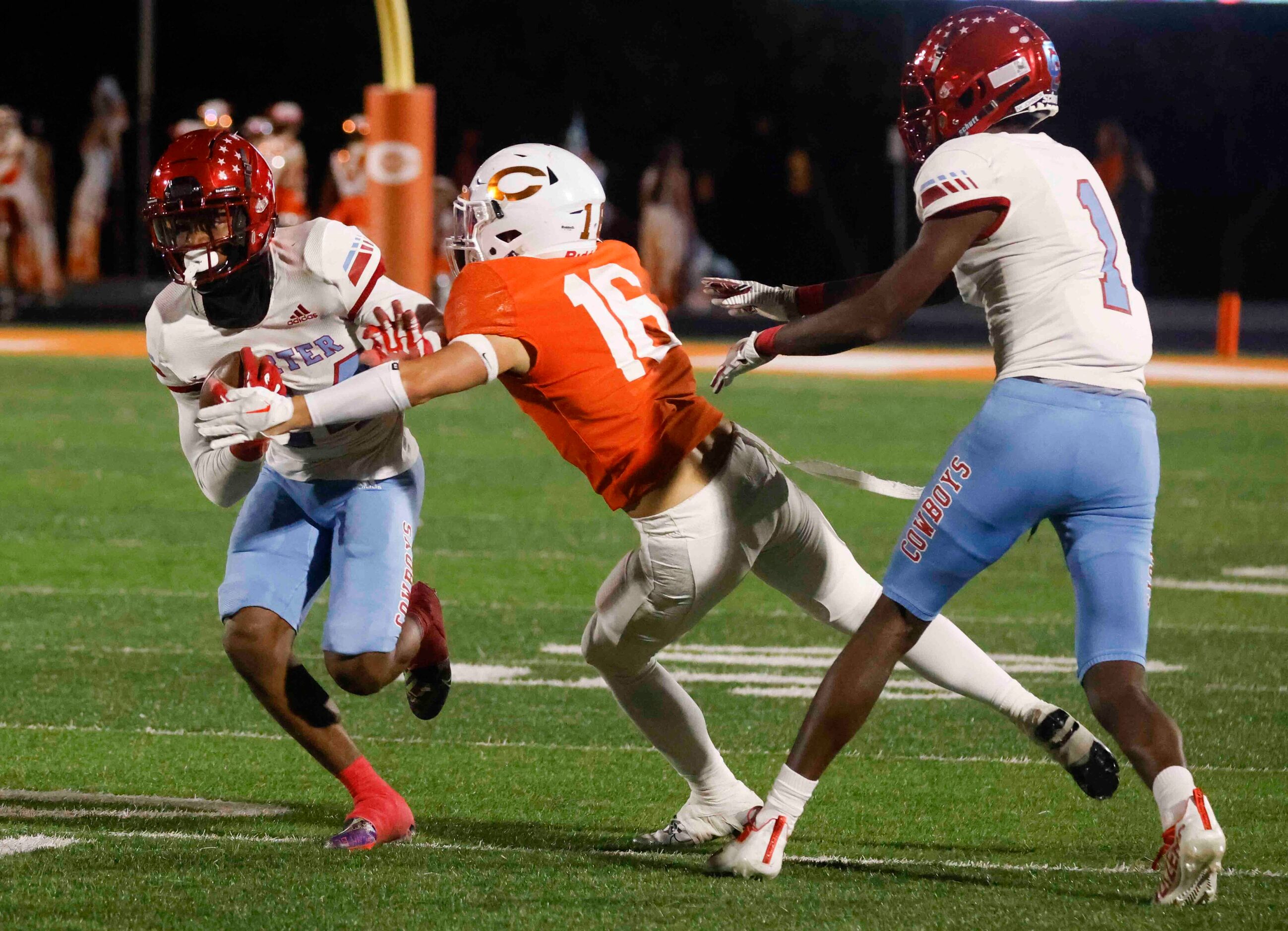 David W. Carter High School’s Kaeden Landry (24), left, gets tackled by Celina High School’s...