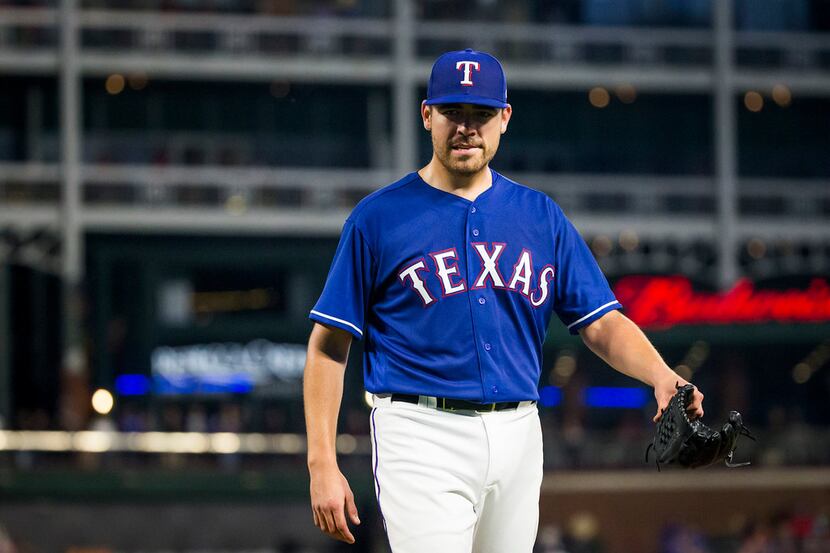 Texas Rangers starting pitcher Matt Moore heads to the dugout after being pulled from the...