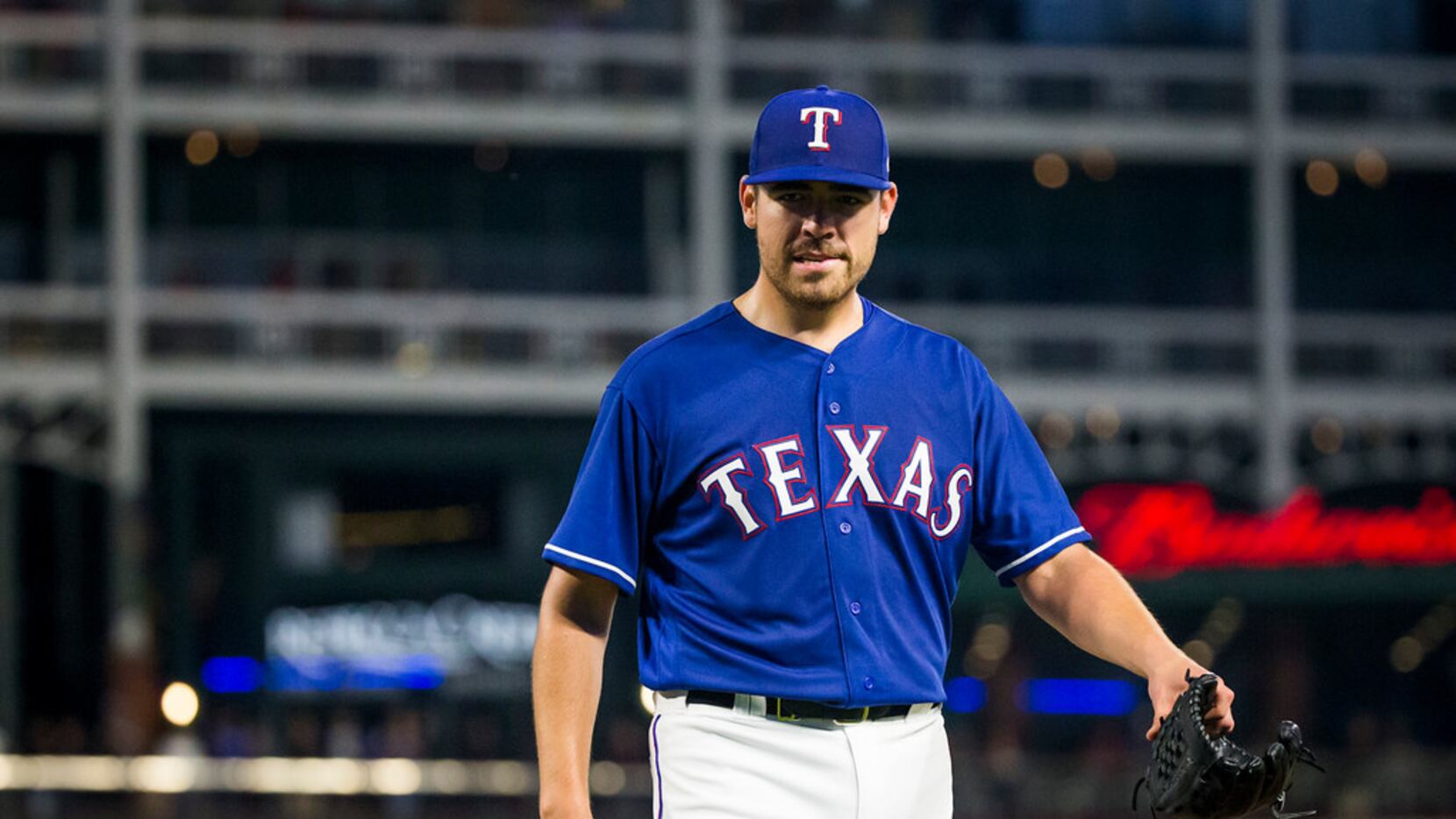 Texas Rangers starting pitcher Matt Moore heads to the dugout after being pulled from the...