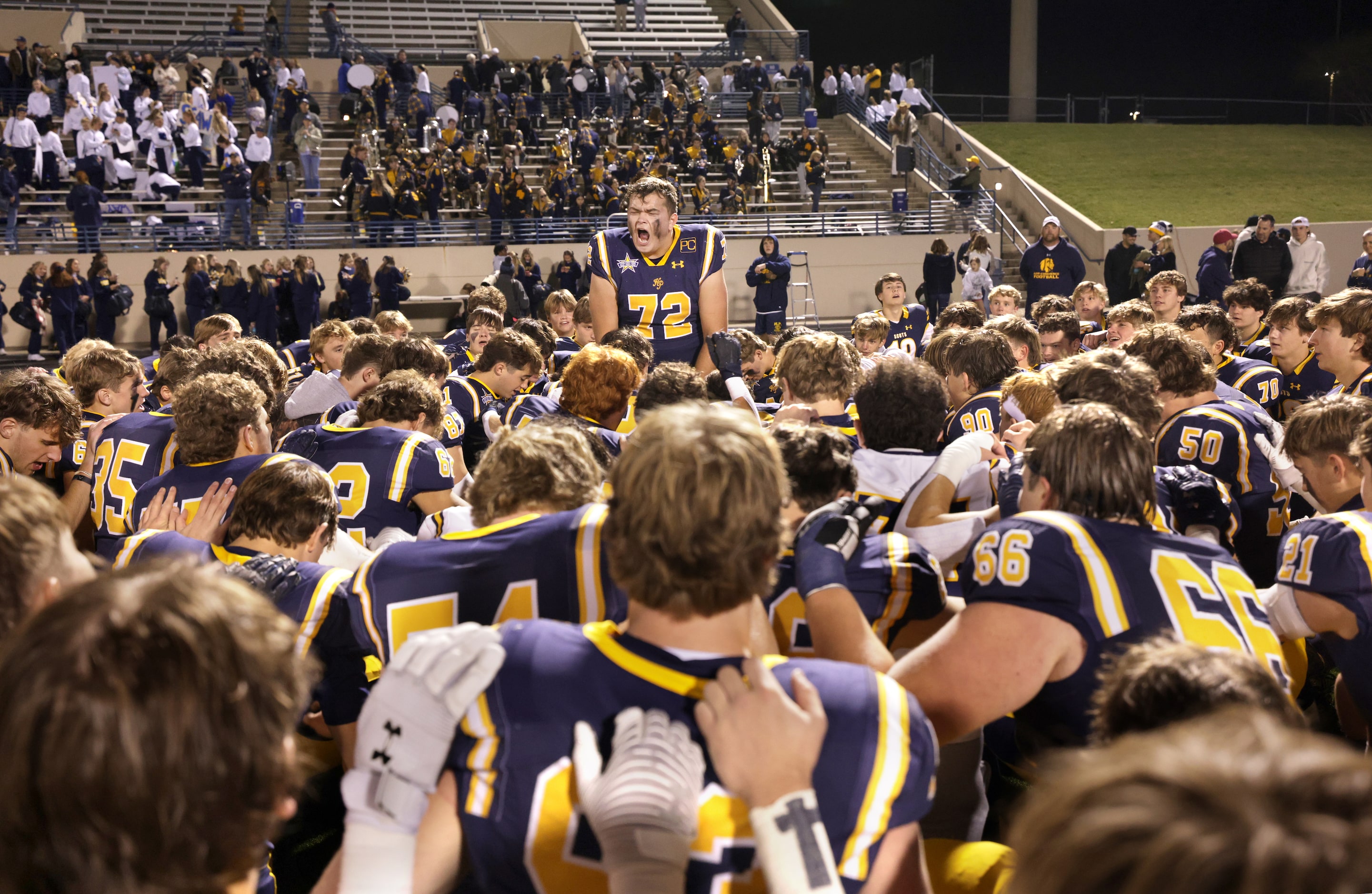 Highland Park High School players pray after winning a football playoff game against...