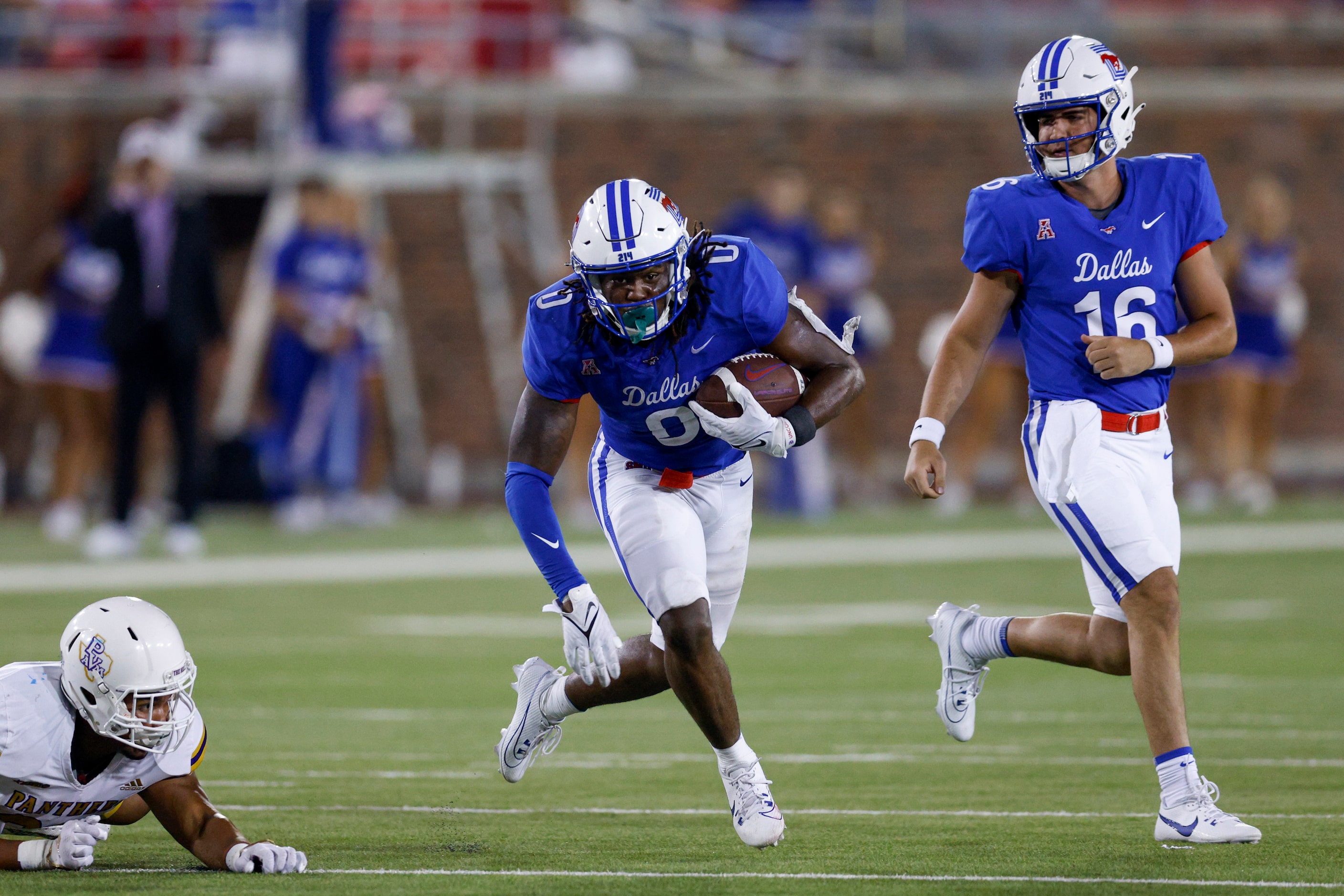 SMU quarterback Alex Padilla (16) watches as running back Camar Wheaton (0) races down field...