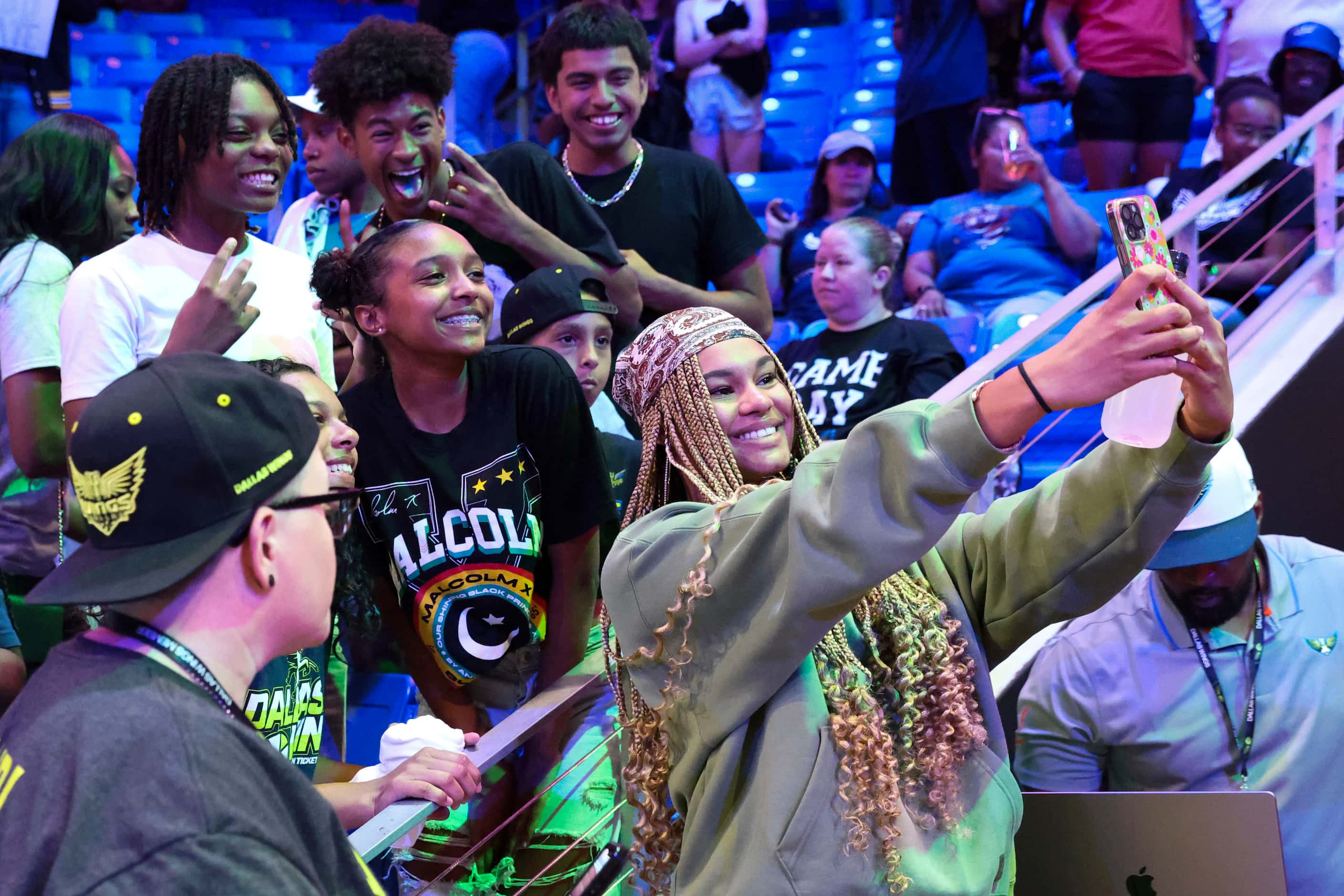 Dallas Wings’ Satou Sabally takes a selfie with fans following a WNBA basketball game...
